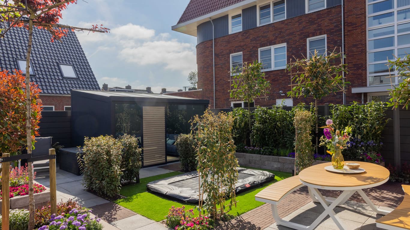 Jardin rénové de Margriet et Roland avec véranda autoportante et plantations à Bergambacht