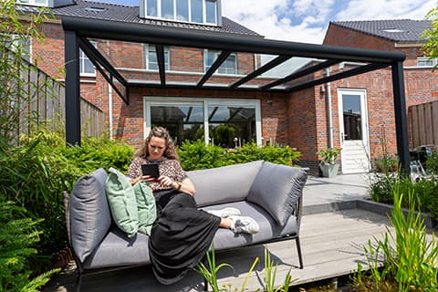 Un jardin avec beaucoup de plantes et une pergola noir mat