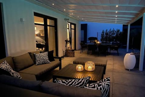 Pergola noir mat avec canapé lounge