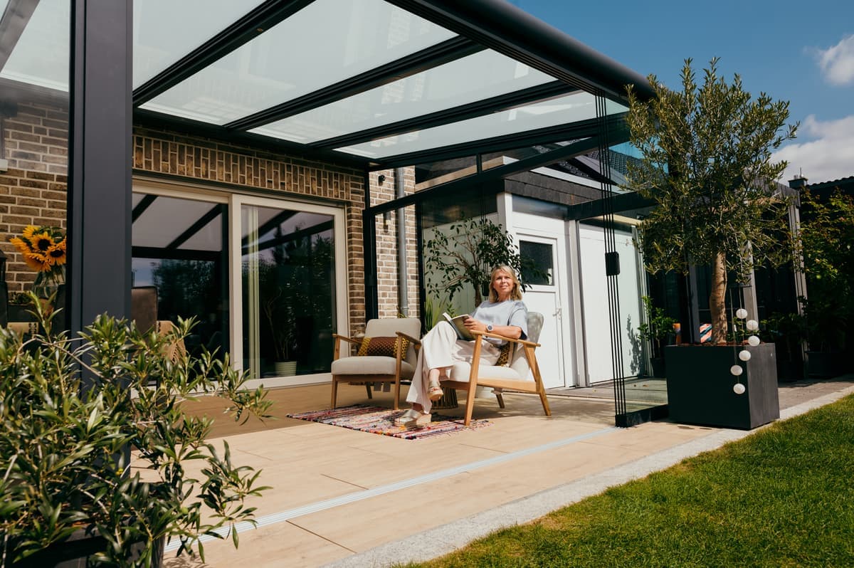 Une véranda moderne avec un toit en verre crée une atmosphère lumineuse et relaxante dans le jardin. Une véranda moderne avec un toit en verre crée une atmosphère lumineuse et relaxante dans le jardin.